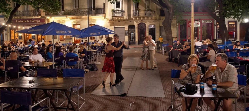 Turistas disfrutando de la vida nocturna y bailando tango en Plaza Dorrego, San Telmo, Buenos Aires